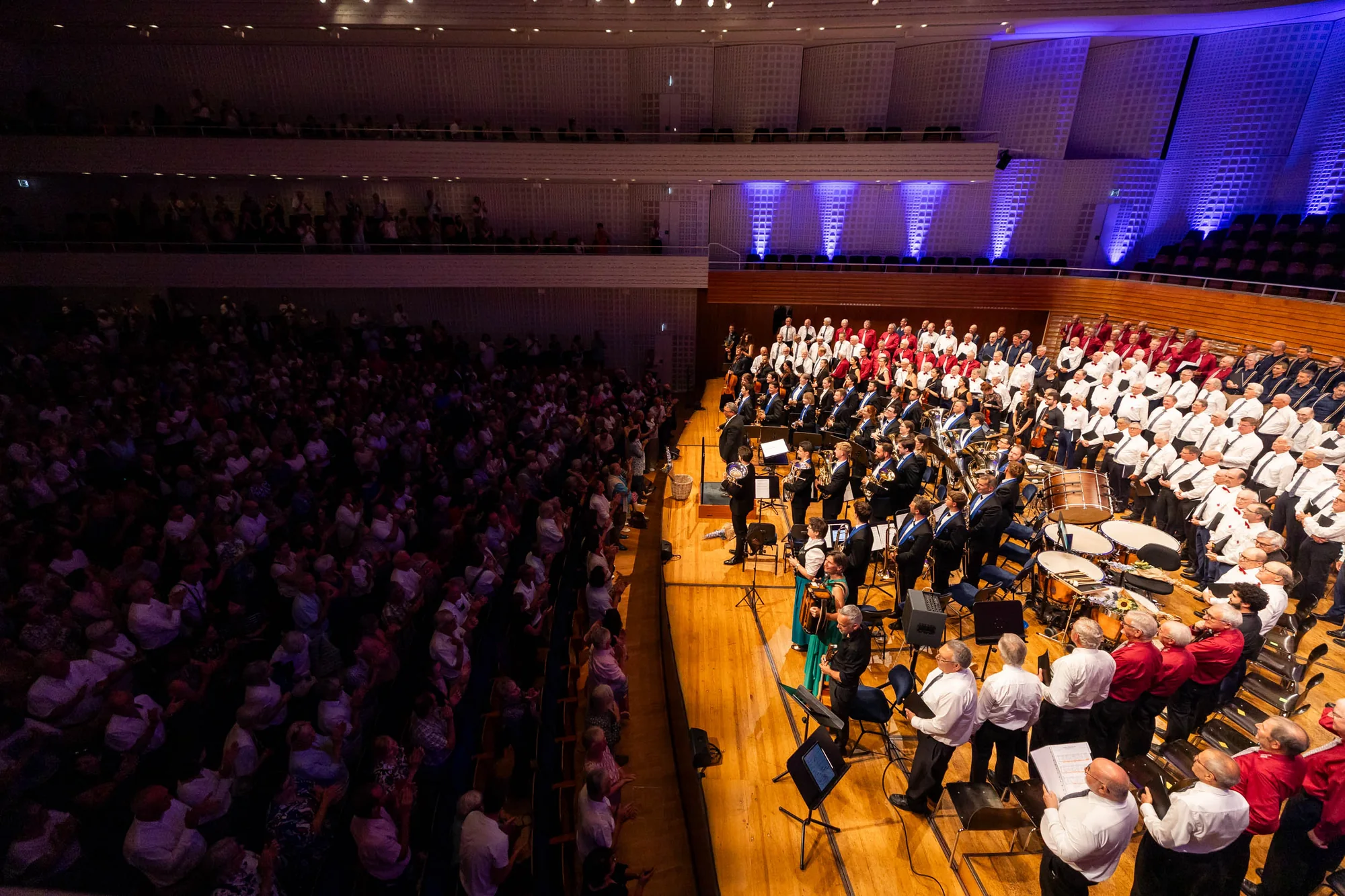 Vista general del KKL Luzern con músicos, coro y público en pie