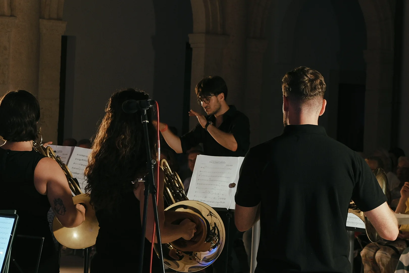 Raúl Sabiote dirigiendo un conjunto de viento metal en un patio · Alboran Brass Ensemble · D’Gata Brass Week 2026